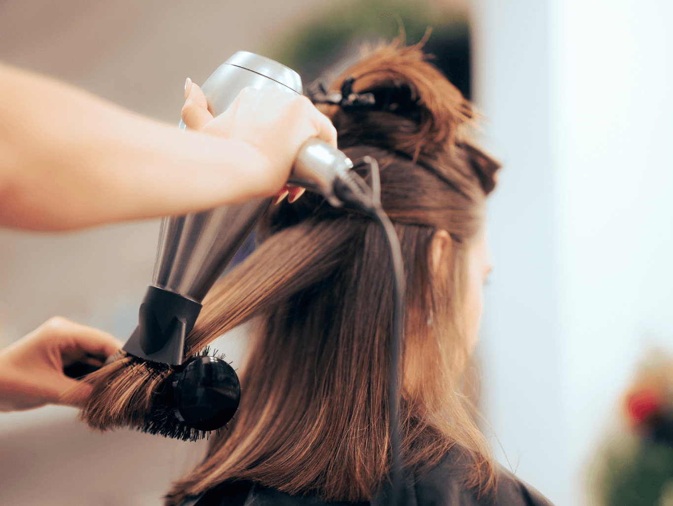 Stylist performing a professional blow-dry on a client’s hair at Honeys Hair & Beauty in Taunton, creating smooth, glossy, salon-fresh results.